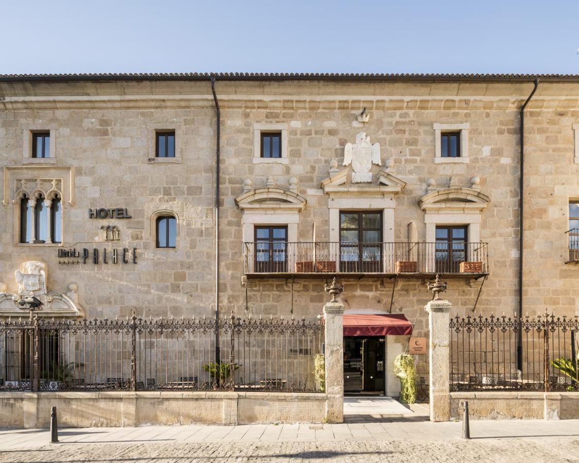Hotel Ilunion Merida Palace Exterior photo The image shows the exterior of a building identified as a hotel. It features a stone facade with architectural details, including windows with decorative elements and a central entrance. There are iron railings and some greenery visible at the base,